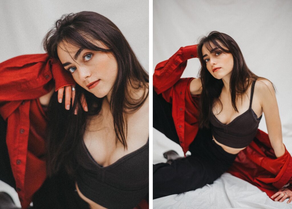 Eine junge Frau mit langen braunen Haaren posiert in einem Haus vor einem weißen Hintergrund, gestylt von einer talentierten Fotografin. Sie trägt ein dunkles Crop-Top, eine schwarze Hose und eine rote Jacke über den Schultern und blickt auf beiden Bildern selbstbewusst in die Kamera.