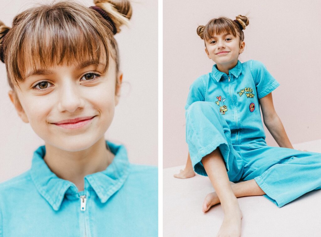 Schwarz-Weiß-Porträt einer Fotografin eines jungen Mädchens mit langen Zöpfen, gemustertem Kopftuch und einfarbigem Hemd, das vor einem schlichten Hintergrund ernst in die Kamera schaut - aufgenommen von einem erfahrenen Fotografen Köln.